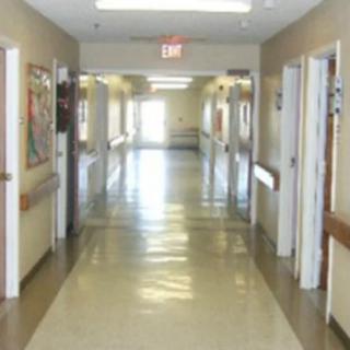 A hospital hallway with doors on both sides and a shiny floor.