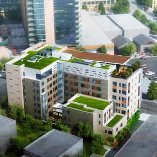 A modern residential building featuring green roofs and urban landscaping.