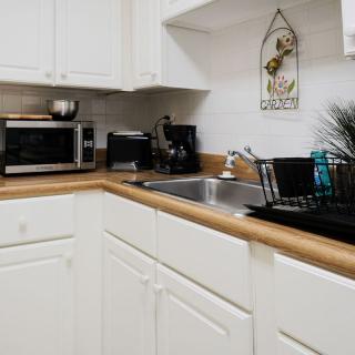 A tidy kitchen corner with white cabinets, a sink, and countertop appliances.