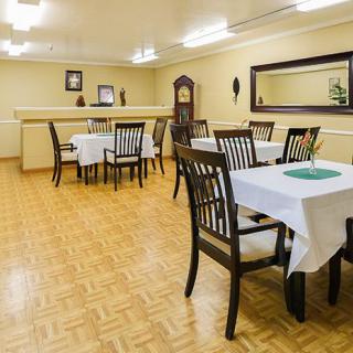 A neatly arranged dining area with tables set with white tablecloths.