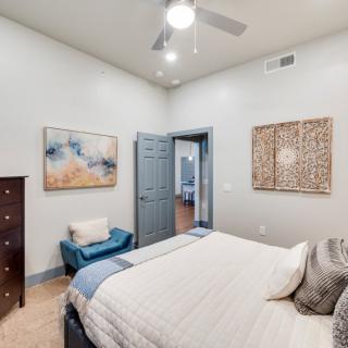 A modern bedroom interior with stylish decor and artwork on the walls.