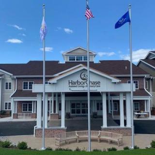A nursing home building with three flags displayed out front.
