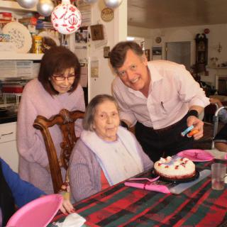 A family celebrating a birthday with a cake and festive decorations.