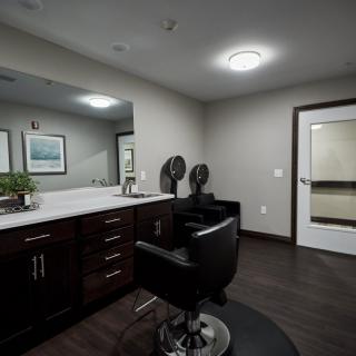 Modern hair salon interior with a barber chair and vanity.
