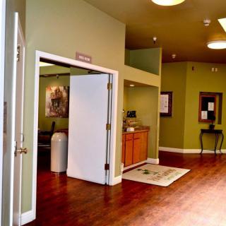A welcoming lobby area with green walls and wooden flooring.