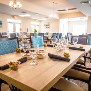 A well-set dining area in a restaurant with neatly arranged tables and chairs.