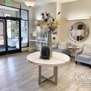 A stylish and inviting lobby featuring modern furniture and a decorative floral centerpiece.