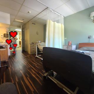 A cozy and well-lit patient room in a hospital, complete with medical equipment and a welcoming atmosphere.