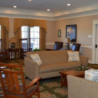 A cozy and well-furnished living room with sofas, chairs, and a large window.
