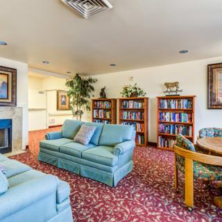 A cozy living room with comfortable seating, bookshelves, and a fireplace.