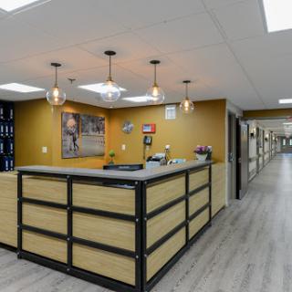 A modern office reception area featuring a sleek desk and stylish lighting.