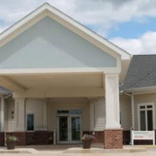 A welcoming entrance to a modern residential building under a partly cloudy sky.