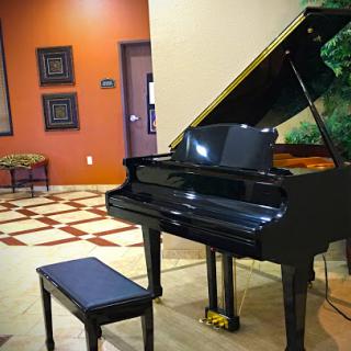 A grand black piano positioned elegantly in a stylish lobby setting.