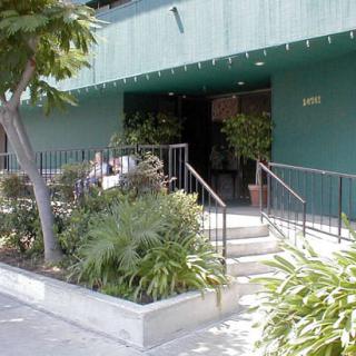 Entrance to a building with stairs and surrounding greenery.