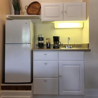 A compact and modern kitchen area featuring essential appliances and white cabinetry.