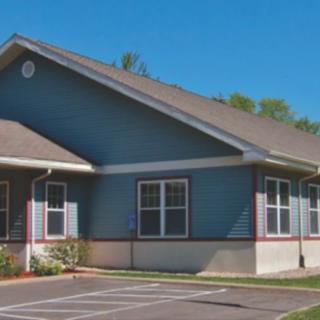 A suburban house with a blue exterior and multiple windows.