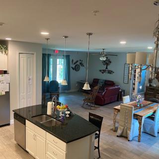 A modern open floor plan featuring a kitchen with an island counter, adjacent dining area, and connected living room.