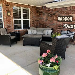 Cozy patio seating area at Hudson House with comfortable furniture and decorative flowers.