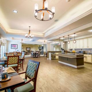 A spacious and modern dining area with elegant lighting and a central kitchen island.