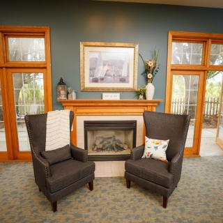 Cozy living room with a fireplace, two armchairs, and decorative elements.