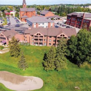 Aerial view of a resort with golf course and surrounding greenery.