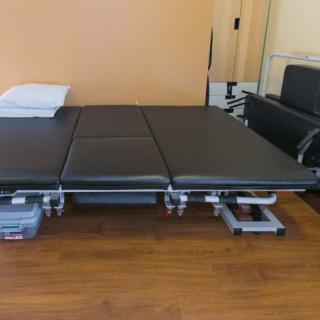 A massage table placed in a therapy room, ready for use in a clinical setting.