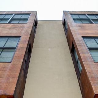 Upward view of a modern building with symmetrical windows and a minimalist facade.