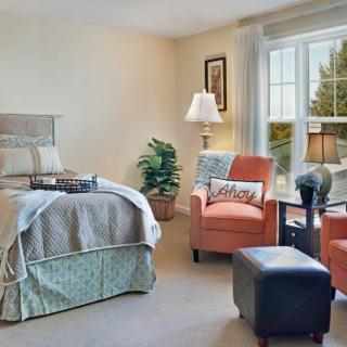 A cozy bedroom with comfortable furnishings and ample natural light.