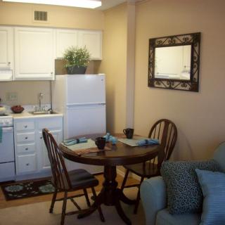 Cozy kitchen and dining area with a small table, chairs, and kitchen appliances.