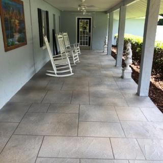 A spacious porch with rocking chairs and a garden view.