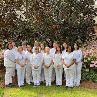 A dedicated team posing together in a beautiful outdoor setting.