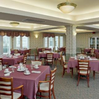 An empty dining room with tables neatly set for guests.