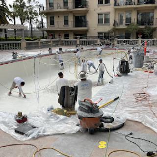 Workers applying a fresh coat to the pool during renovation.