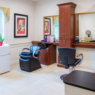 A well-equipped hair salon with seating and mirrors, designed for a comfortable beauty experience.