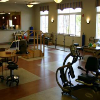 A well-equipped physical therapy room with various exercise machines and equipment.