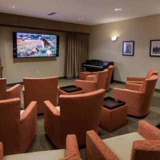 A cozy home theater room with comfortable seating and a large television.