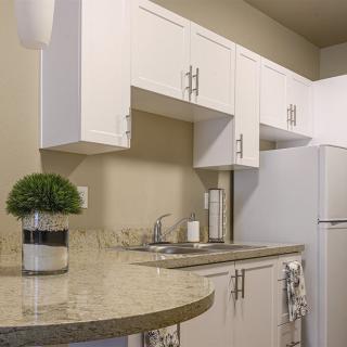 A modern kitchen with white cabinets and a sleek countertop.