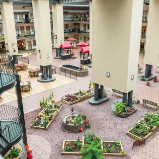 A spacious atrium featuring lush indoor gardens and comfortable seating areas.