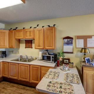 A cozy kitchen with wooden cabinets and various appliances, including a microwave and coffee maker.