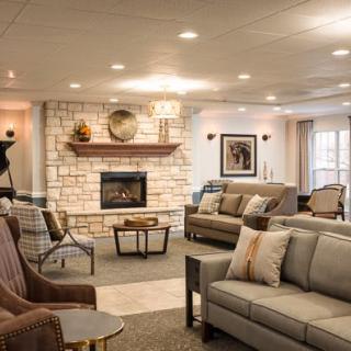 A cozy living room with a stone fireplace and comfortable seating.