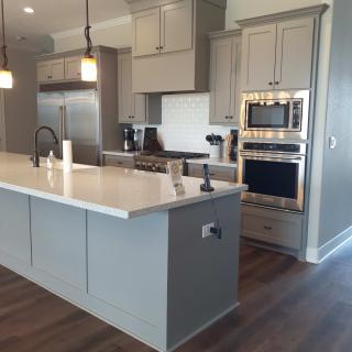 A modern kitchen with an island, stainless steel appliances, and pendant lighting.