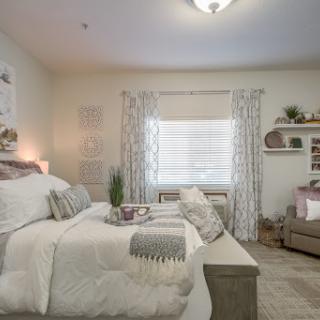 A beautifully decorated cozy bedroom with soft tones and stylish furnishings.