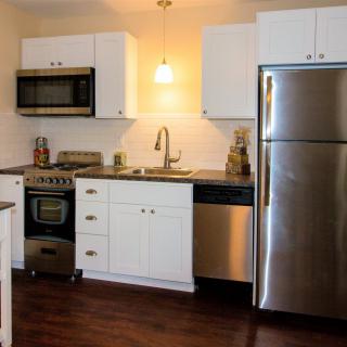 A modern kitchen with stainless steel appliances and white cabinetry.