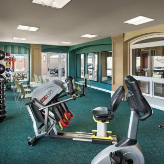 A gym with various fitness equipment and exercise machines.