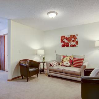 A cozy living room with a sofa, armchairs, and stylish decor.