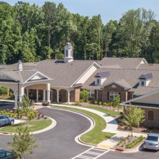 Aerial view of a large facility with landscaped grounds and a circular driveway.