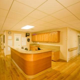 A modern reception desk area with wooden furniture and a clean, organized look.
