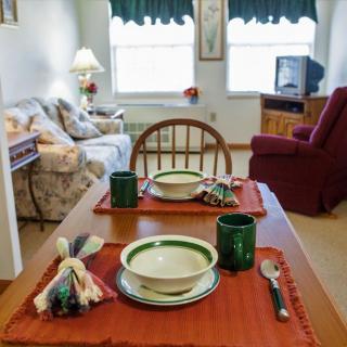 A cozy living room with a set dining table and comfortable seating area.
