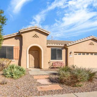 A single-story stucco house with desert landscaping and a two-car garage.