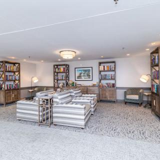 A spacious lobby with comfortable seating and bookshelves.